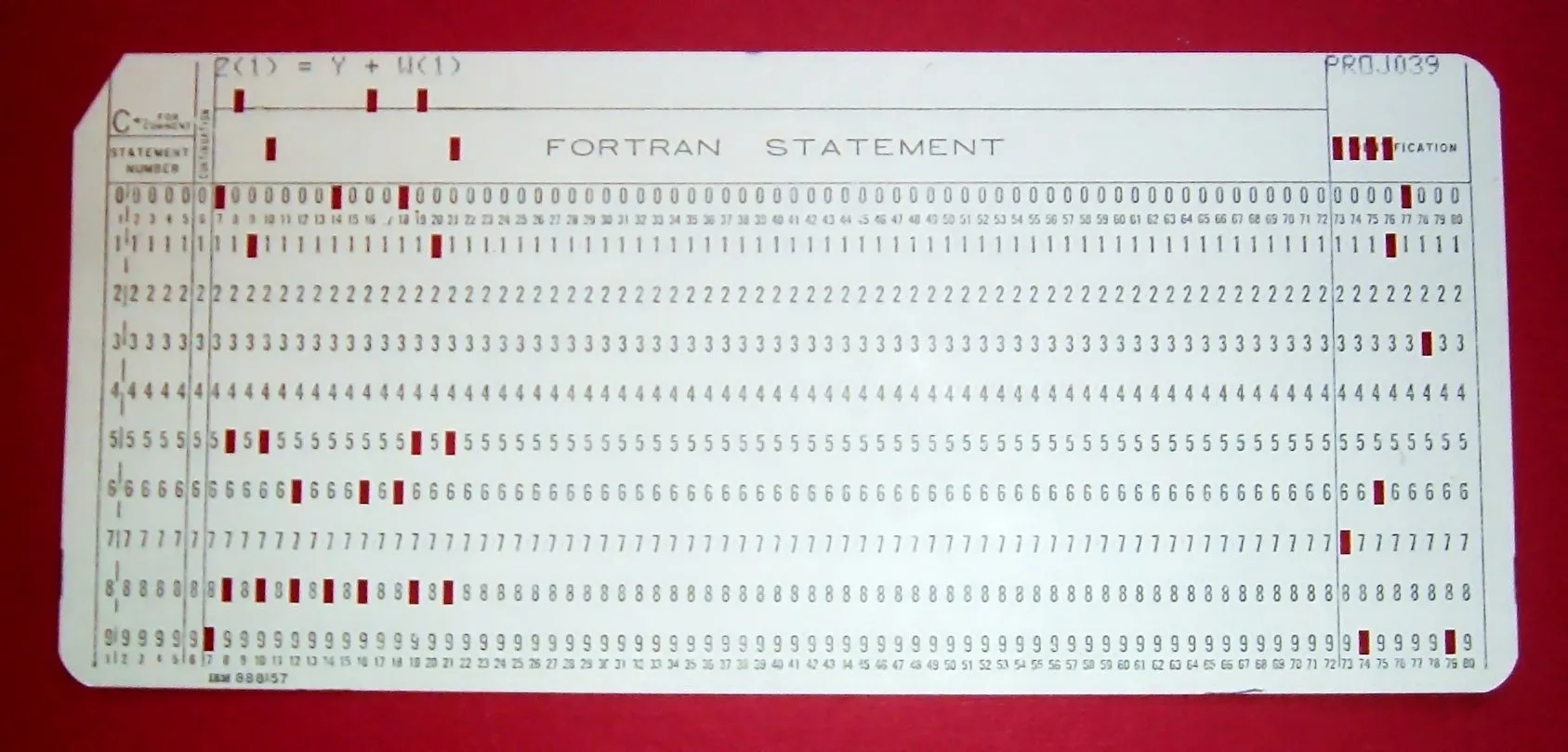 A beige punched card with 80 columns of printed digits; red marks show where holes are punched, and the top line reads Z(1) = Y + W(1).