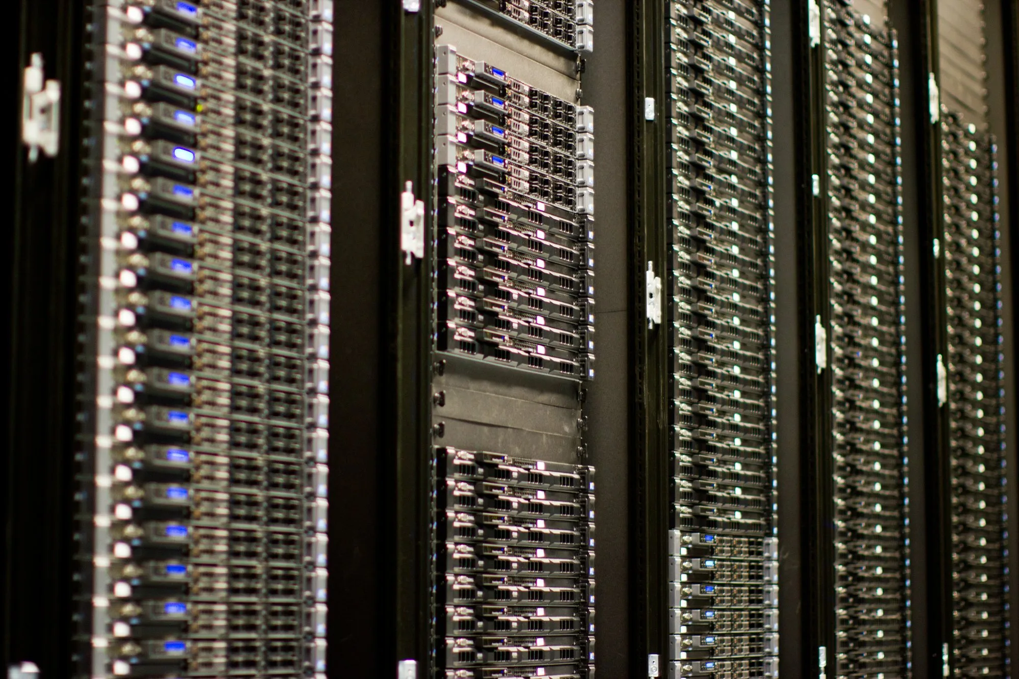 Tall racks of web servers with rows of small blue lights in a data centre.